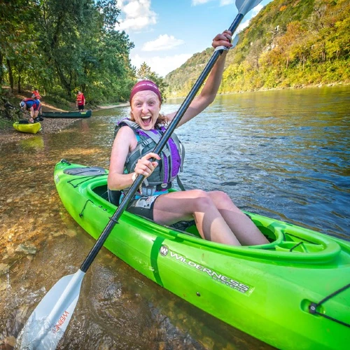 enthusiastic girl in Canoe with paddle ready to float.