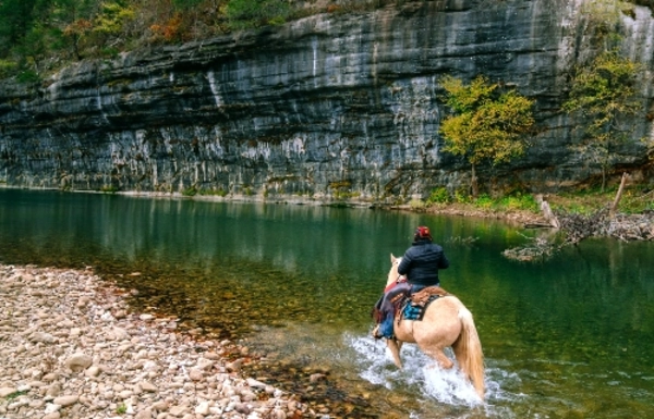 canoes floating on the river in front of a bluff