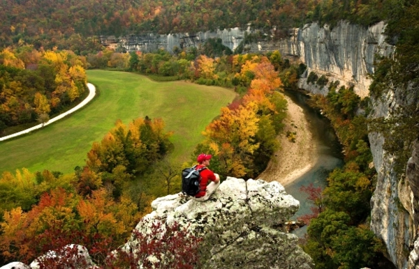 canoes floating on the river in front of a bluff