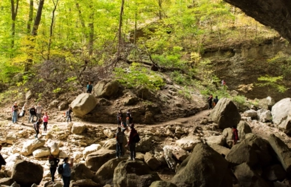 canoes floating on the river in front of a bluff